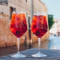 Two glasses of Spritz Veneziano cocktail served near the Venetian canal