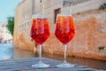 Two glasses of Spritz Veneziano cocktail served near the Venetian canal.