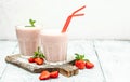 Two glasses of Strawberry smoothie or milkshake with berries and yogurt on white background. Vegetarian healthy drink. place for Royalty Free Stock Photo