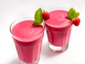 Glasses of strawberry smoothies on a white background