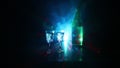 Two glasses of Vodka with bottle on dark foggy club style background with glowing lights Laser, Stobe Multi colored. Club drinks