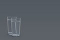 Two glasses of water in corner on gray background Royalty Free Stock Photo