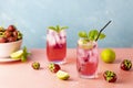 Two glasses with water drops of Strawberry mojito cocktail on light blue color background, pink board. Copy space, summer vacation Royalty Free Stock Photo