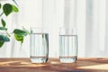 Two glasses of water standing on wooden table inside Royalty Free Stock Photo