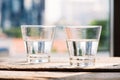 Two glasses of water on table on wooden background Royalty Free Stock Photo