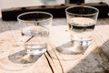 Two glasses of water on table on wooden background Royalty Free Stock Photo