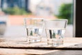 Two glasses of water on table on wooden background Royalty Free Stock Photo