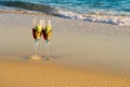 Two glasses in a wave of the sea on the beach Royalty Free Stock Photo