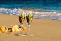 Two glasses in a wave of the sea on the beach Royalty Free Stock Photo