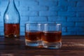 Two glasses of whiskey and a bottle on wooden table, copy space. Royalty Free Stock Photo