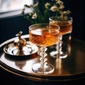 Two glasses Whiskey cocktail on the table on a blurred background of flowers