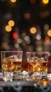 Two glasses of whiskey with ice on a bar counter, dark background with bokeh. Royalty Free Stock Photo