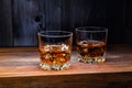 Two glasses of whiskey with ice cubes on an wooden board Royalty Free Stock Photo