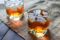 Two glasses of whiskey with ice cubes served on wooden planks. Royalty Free Stock Photo