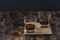 Two Glasses of whiskey with ice cubes on a wooden table/Two Glasses of whiskey with ice cubes on a wooden table. Black background Royalty Free Stock Photo