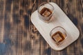 Two Glasses of whiskey with ice cubes on a wooden table/Two Glasses of cognac with ice cubes on a wooden table. Top view, Royalty Free Stock Photo