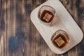 Two Glasses of whiskey with ice cubes on a wooden table/Two Glasses of cognac with ice cubes on a wooden table. Top view, Royalty Free Stock Photo