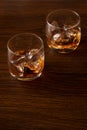 Two glasses of whiskey with ice on a wooden background Royalty Free Stock Photo