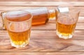 Two glasses of whisky with bottle of whiskey on wooden background Royalty Free Stock Photo