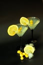 Two glasses of white vermouth with lemon wedges and olives on a black background with ice Royalty Free Stock Photo