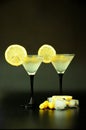 Two glasses of white vermouth with a slice of lemon, olives and ice cubes on a black background Royalty Free Stock Photo