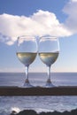 Two glasses of white wine on a background of sky and sea. Romantic dinner for two by the sea. Summer evening Royalty Free Stock Photo