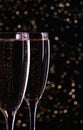 Two glasses with white wine champagne on a black background with golden bokeh.  Festive concept Royalty Free Stock Photo