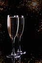 Two glasses with white wine champagne on a black background with golden bokeh.  Festive concept Royalty Free Stock Photo