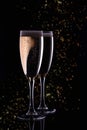 Two glasses with white wine champagne on a black background with golden bokeh.Festive concept Royalty Free Stock Photo