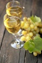 Two glasses of white wine and grape on wooden background Royalty Free Stock Photo