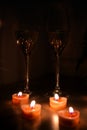 Two glasses of white wine with small red candles in night time. Romantic and love rendezvous concept Royalty Free Stock Photo