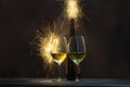 Two glasses of wine with bottles of wine with fireworks background Royalty Free Stock Photo