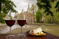 Two glasses of wine with charcuterie assortment on view of Bruges, Belgium. Glass of red wine with different snacks - plate with