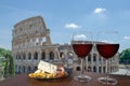 Two glasses of wine with charcuterie assortment on view of Colosseum Coliseum in Rome, Italy. Glass of red wine with different