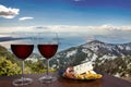 Two glasses of wine with charcuterie assortment on view of mountains and sea in Croatia. Glass of red wine with different snacks