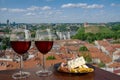 Two glasses of wine with charcuterie assortment on view of Vilnius, Lithuania. Glass of red wine with different snacks - plate