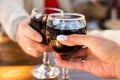 Two glasses of wine in the hands of man and woman with a blurred background and bokeh