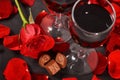 two glasses of wine, rose, petals and chocolates on a black background Royalty Free Stock Photo