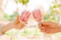 Two glasses of wine with sakura petals. female and male hands