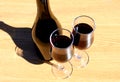 Two glasses of wine stand on a table under direct sunlight Royalty Free Stock Photo