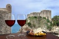 Two glasses of wine with view of Fortress Lovrijenac from Dubrovnik city walls, Dubrovnik, Croatia. Glass of red wine with