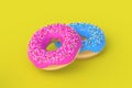 Two glazed donuts on yellow background. Homemade bakery. Break time. Sweet dessert