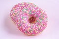 Two glazed pink donuts with icing on pink minimal background, top view