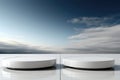 Two glossy white cylindrical platforms for product demonstration on sky background
