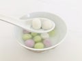 Two glutinous rice balls scooped up from a white bowl on a white spoon. select focus.