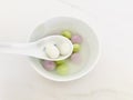 Two glutinous rice balls scooped up from a white bowl on a white spoon. top view.