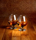 Two goblets of brandy on wooden counter top