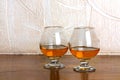 Two goblets of brandy on wooden counter top Royalty Free Stock Photo