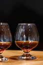 Two goblets of brandy on wooden old counter top Royalty Free Stock Photo