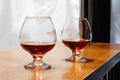 Two goblets of brandy on wooden old counter top Royalty Free Stock Photo